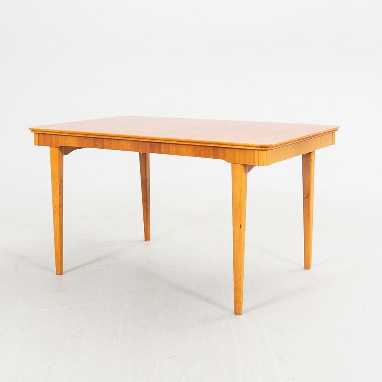 A 1940s mahogany and walnut dining table.
