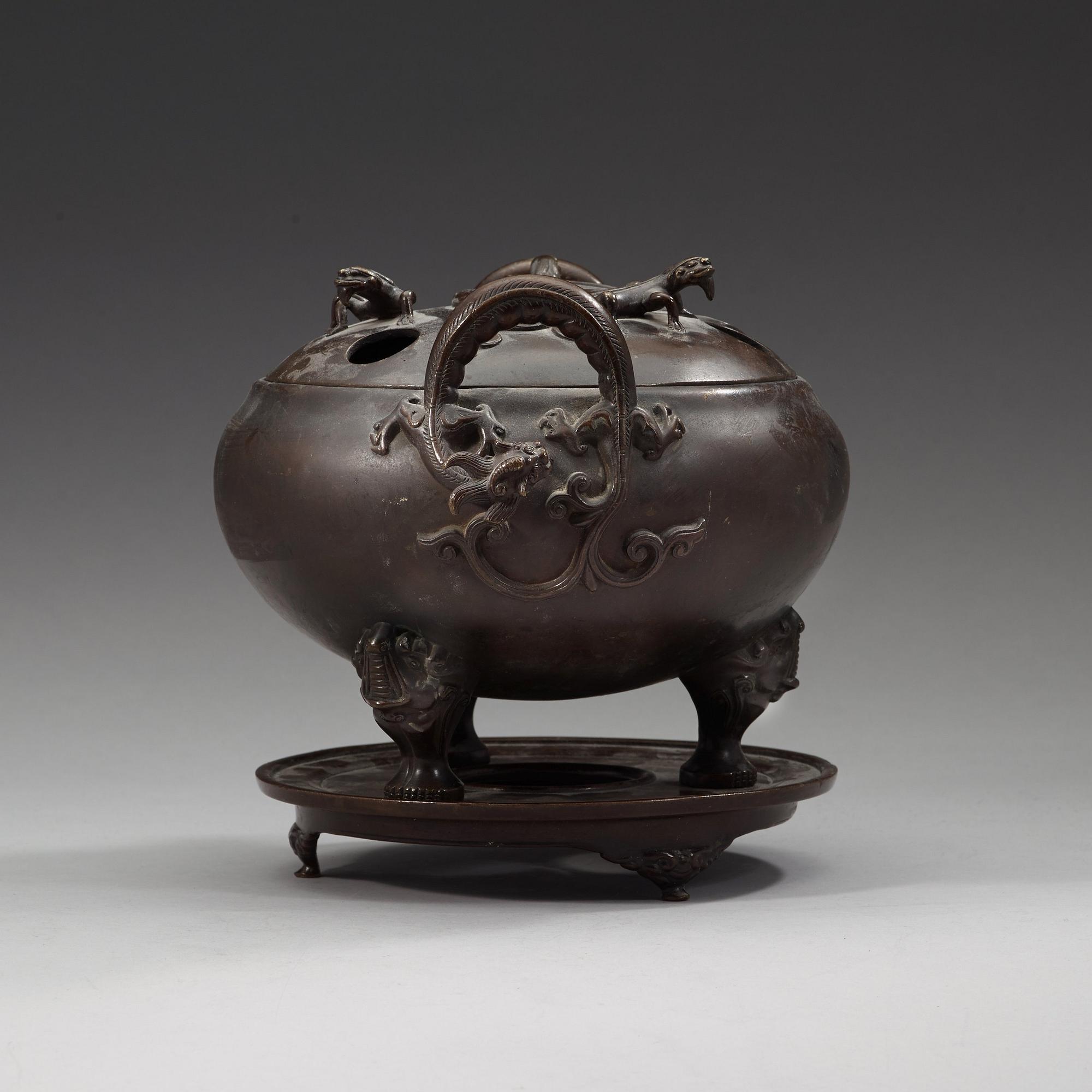 A bronze tripod censer with cover and stand, Qing dynasty, 17/18th Century.