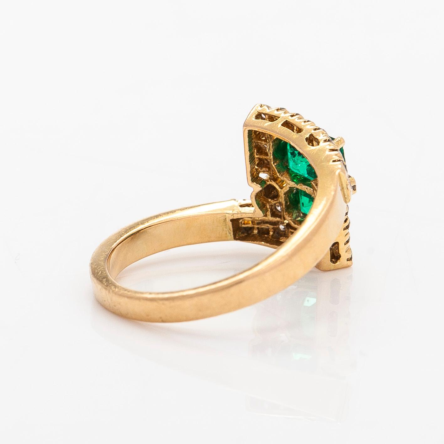 An 18K gold ring with emeralds and diamonds.