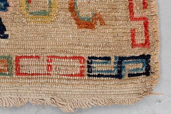 A rug, antique Tibet, ca 71 x 57,5-59 cm (as well as 1,5 cm flat weave at one end).