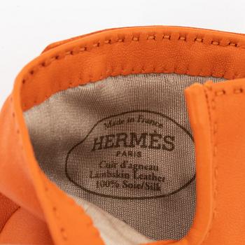 Hermès, a pair of orange kidskin and lambskin gloves, french size 8.