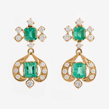 A pair of 18K gold earrings with faceted emeralds and round brilliant-cut diamonds.