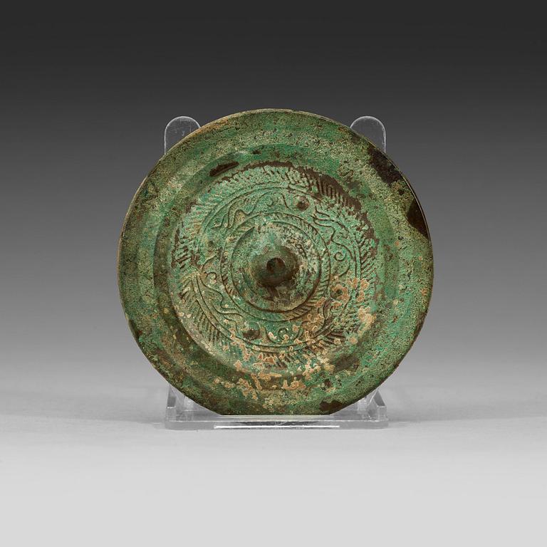 A bronze mirror decorated with a highly stylized dragon-pattern, Han dynasty (206 BC - AD 220).