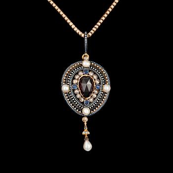 959. A 4.49 cts garnet pendant, adorned with sapphires and oriental pearls. Enamel.