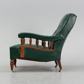 An early 20th Century easy chair with leather upholstery.