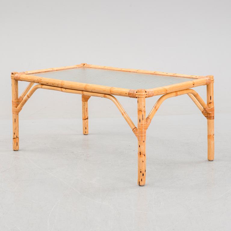 A set of two garden sofas, an armchair and a glass table, later part of the 20th Century.