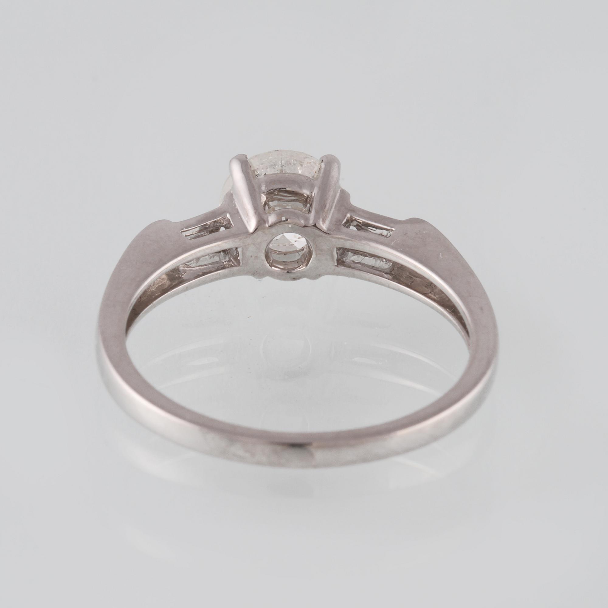 RING, 18K vitguld med briljantslipad diamant 1.14 ct samt 2 baguetteslipade diamanter 0.20 ct. Vikt 3,5 gram.