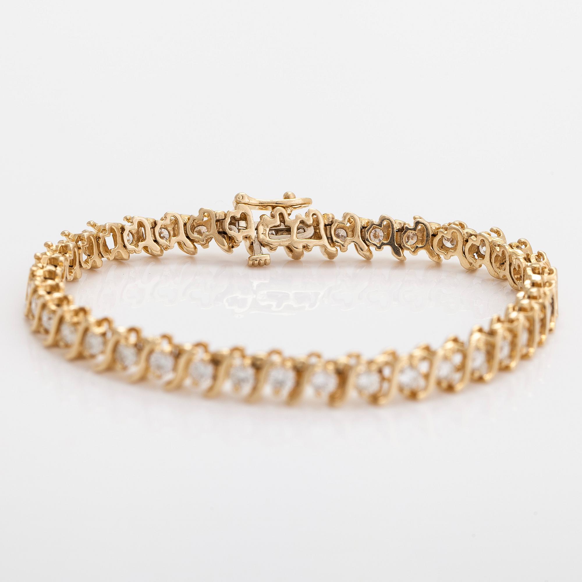 A 14K gold tennis bracelet, with brilliant-cut diamonds.