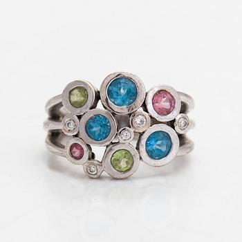 Cassandra Goad, sormus, "Cirkel", 18K valkokultaa, timantteja noin 0.08 ct ja monivärisiä jalokiviä. Lontoo.