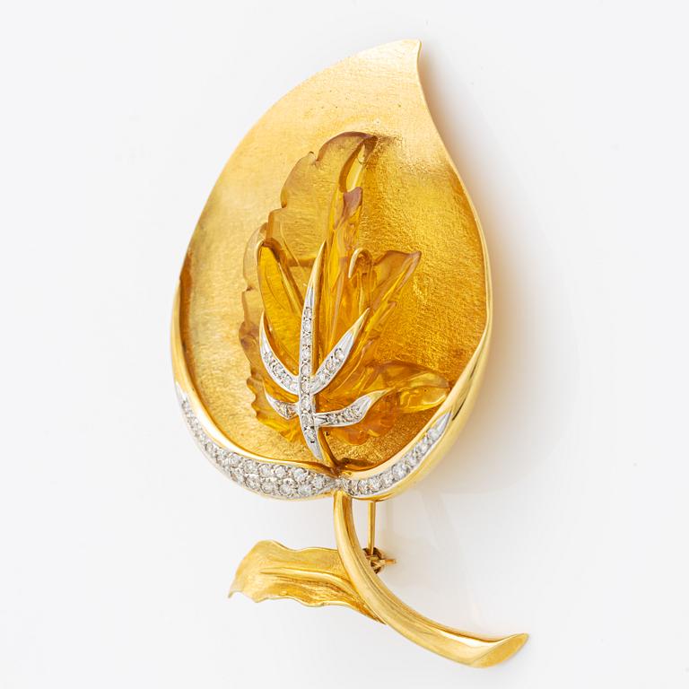 Brooch in 18K gold with carved stone, likely citrine, with round brilliant-cut diamonds.