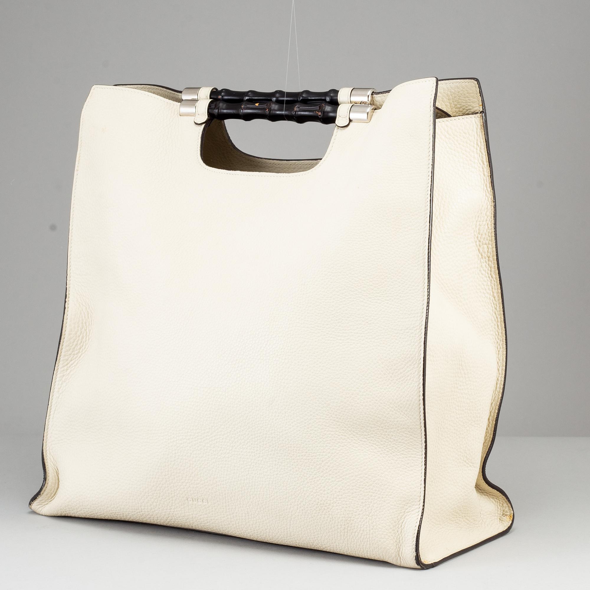 GUCCI, a white leather tote bag with bamboo handles.