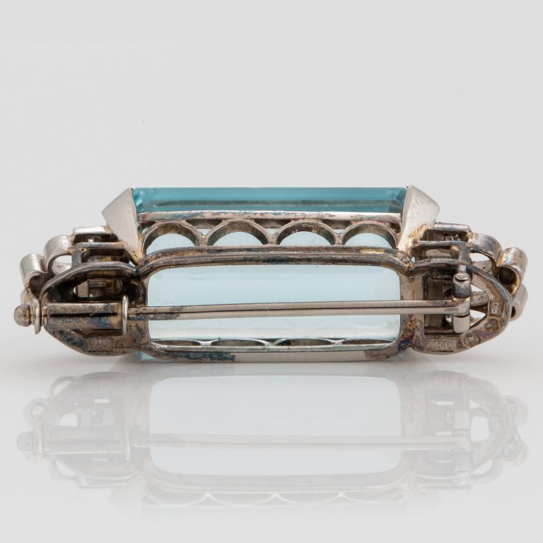 A CF Carlman brooch in 18K white gold set with a faceted aquamarine and eight-cut diamonds.