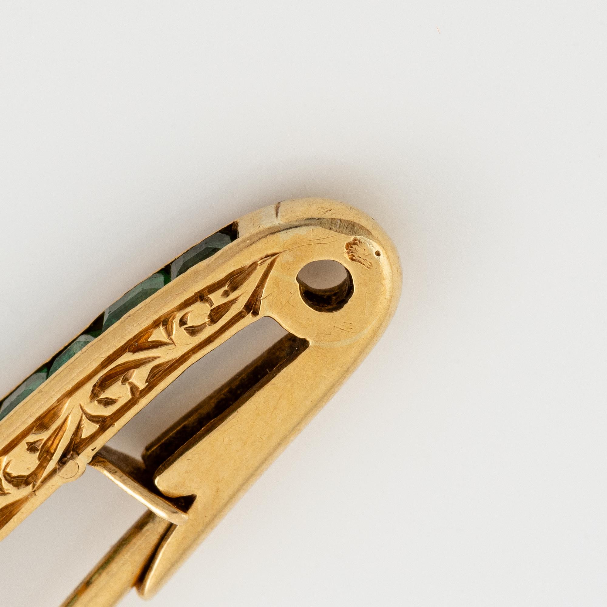 Brosch, längre modell, guld med carréslipade smaragder och gammalslipade diamanter, troligen omkring sekelskiftet 1900.