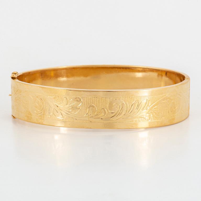 An 18K gold bangle.