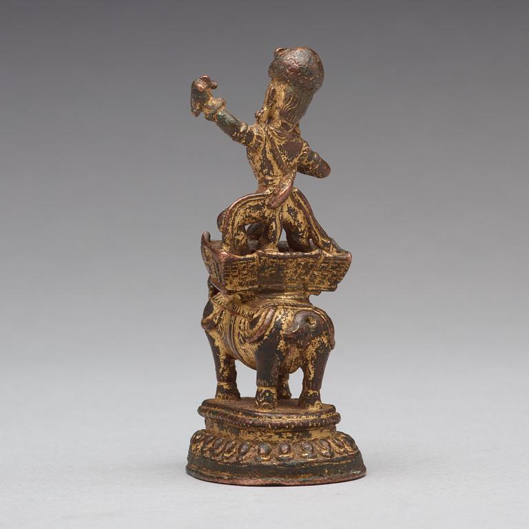 A gilt bronze figure of a deity on an elephant, presumably Nepal, 15th Century.