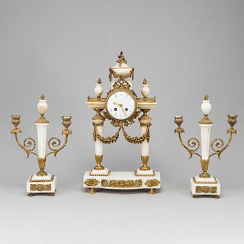 A Louis XVI-style mantle clock and a pair of candelabras. Early 20th century.