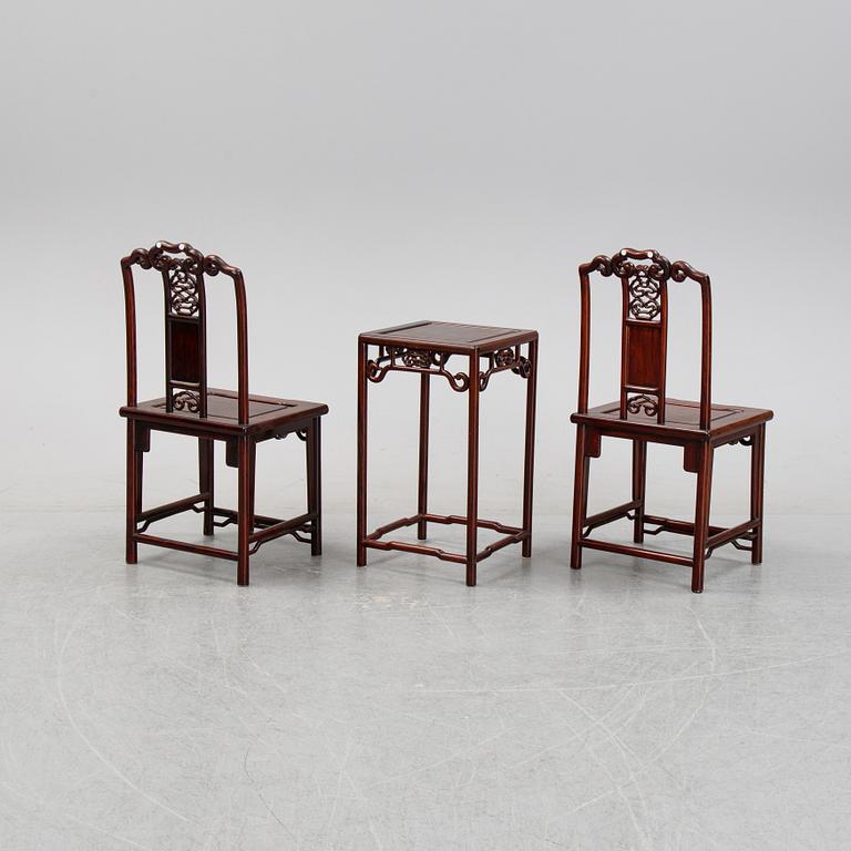 A pair of Chinese hardwood contemporary chairs and table.