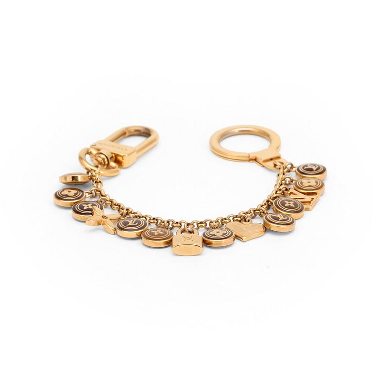 LOUIS VUITTON, a brass bag charm.