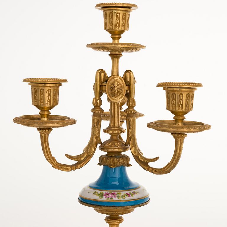 A mid-19th-century French gilt-brass mantel clock with a pair of candelabra by Dussault.