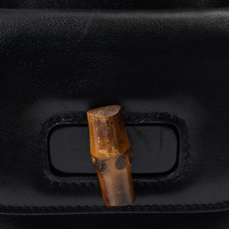 Gucci, A black leather backpack.