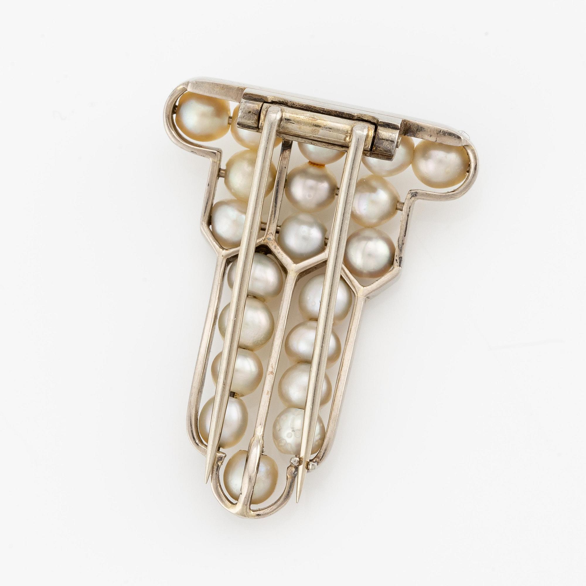 A brooch in 18K white gold set with natural pearls.