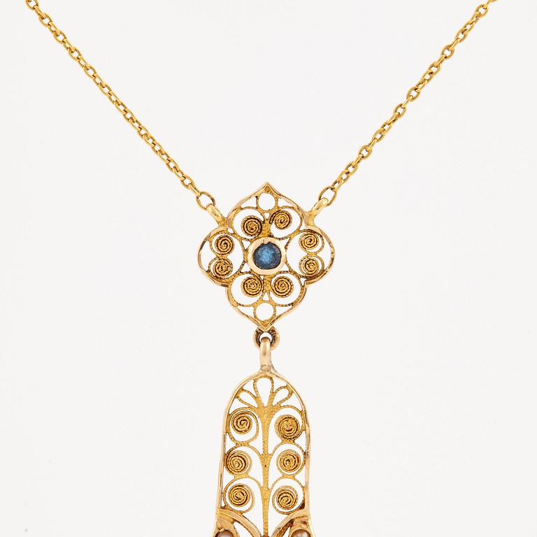 A necklace set with seed pearls, a cabochon cut sapphire, probably another sapphire and filigree work.