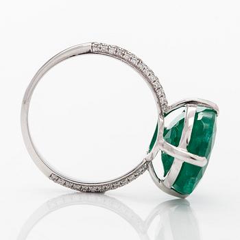 A 14K white gold ring, set with an oval-cut emerald and diamonds. Accompanied with IGI certificate.