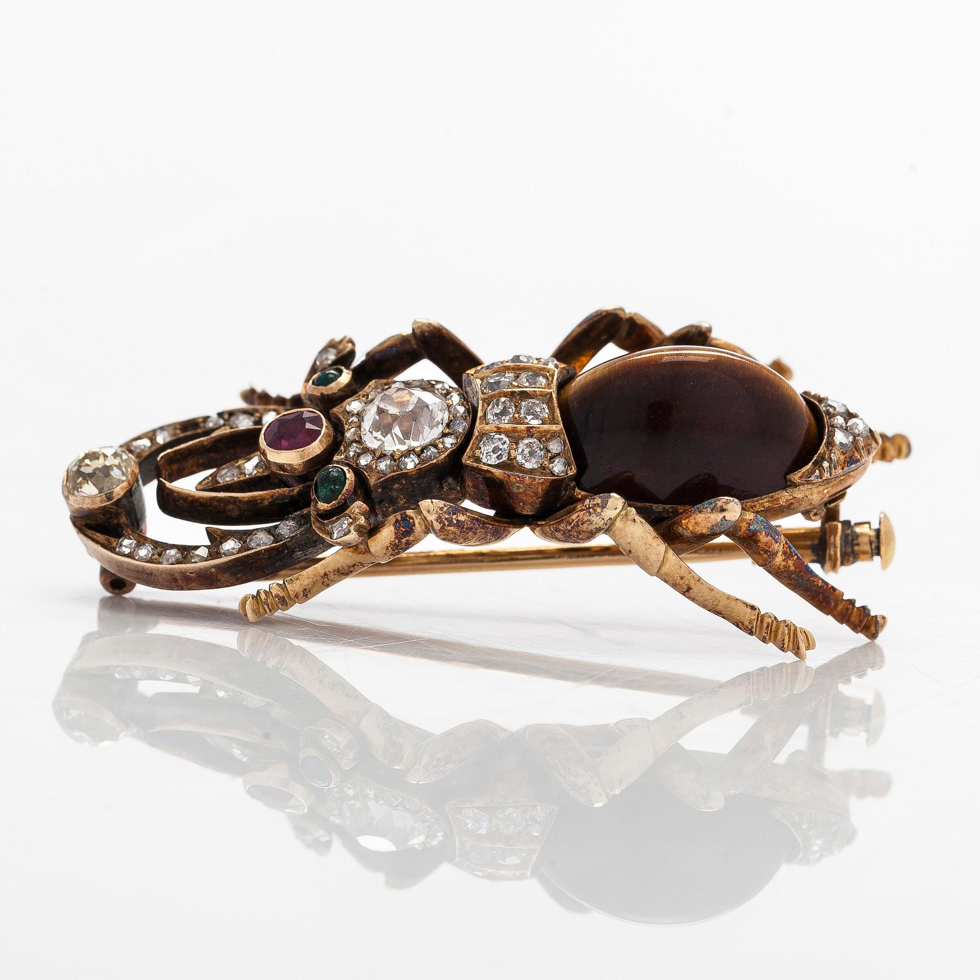 A 14K gold brooch with tiger’s eye, old-cut and rose-cut diamonds, ruby, emeralds. St. Petersburg.