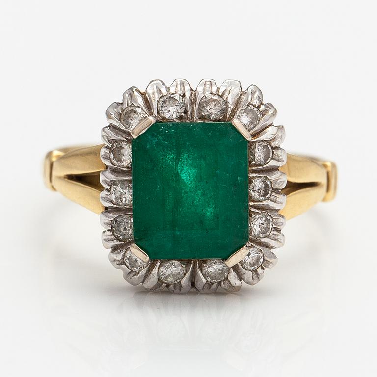 An 18K gold ring with diamonds ca. 0.21 ct and an emerald.