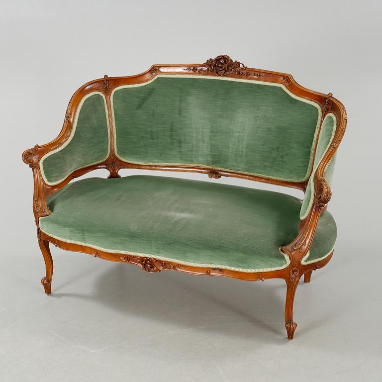 A rococo style sofa, two lounge chairs and a table, around the year 1900 and first half of the 20th century.