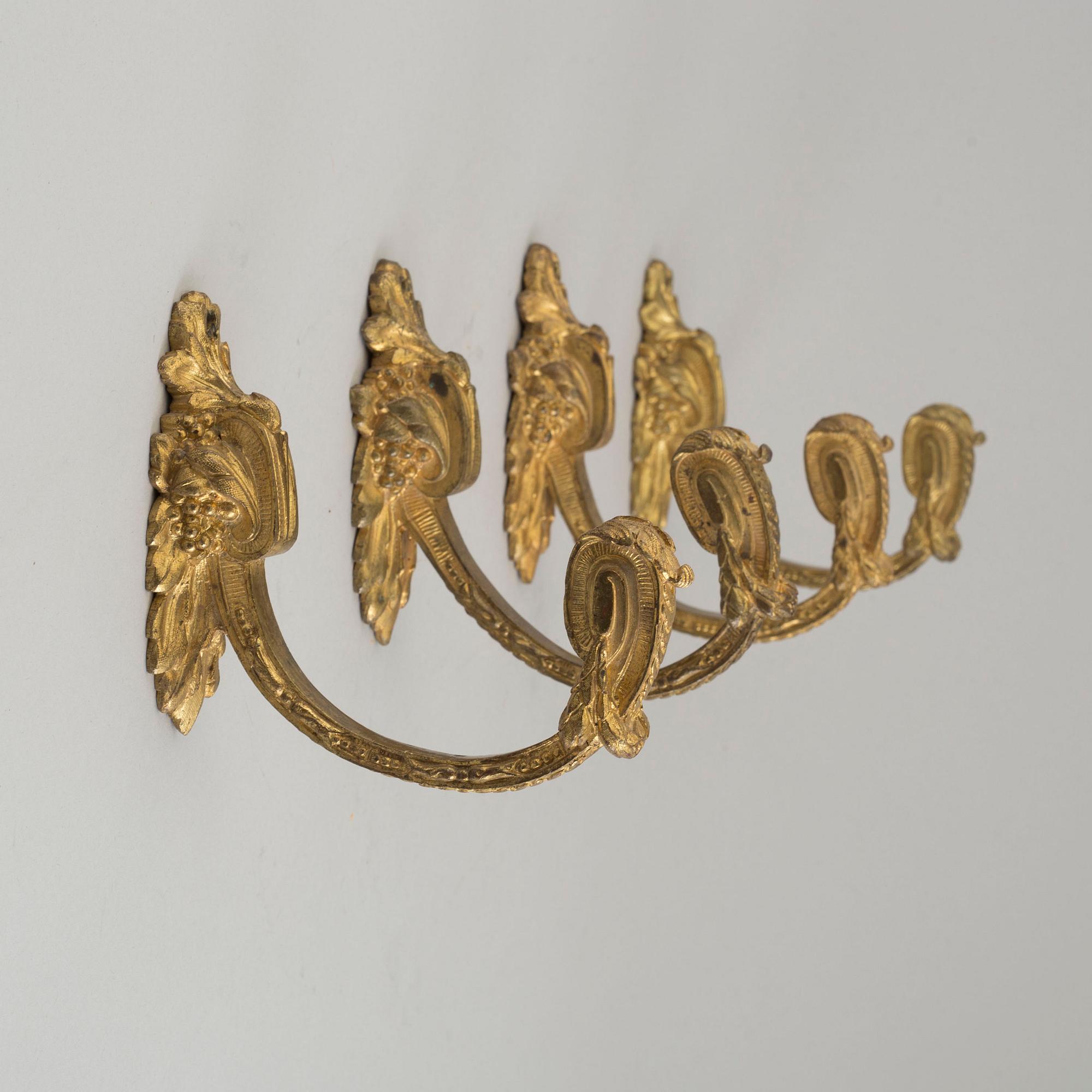 Four 19th century bronze tie-backs.