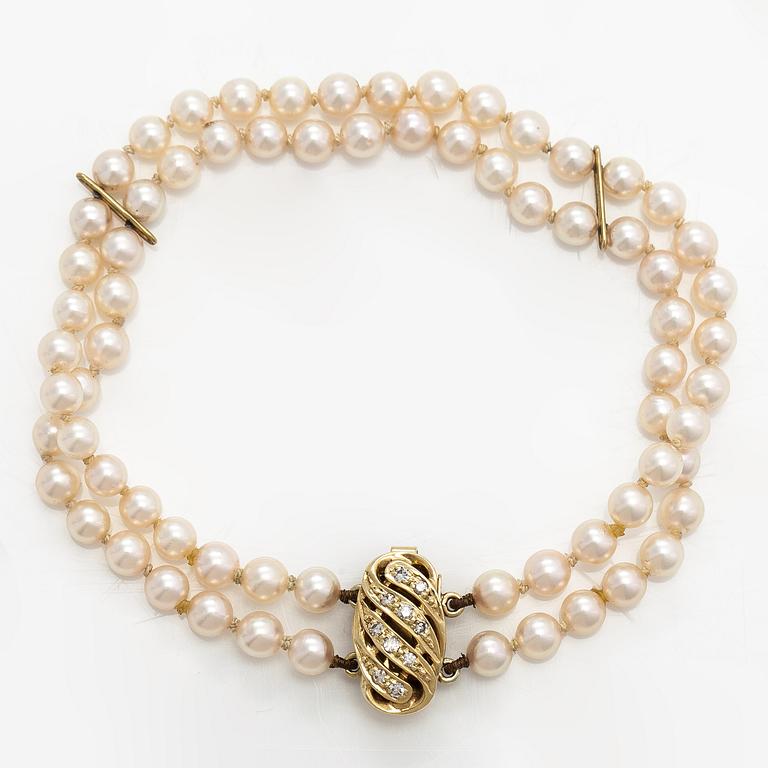 A 2-strand pearl bracelet with cultured pearls, lock 14K gold and diamonds, ca 0.13 ct in total.