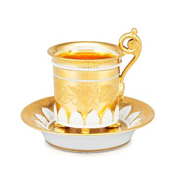 344. A gilded French Empire cup with stand, 19th Century.