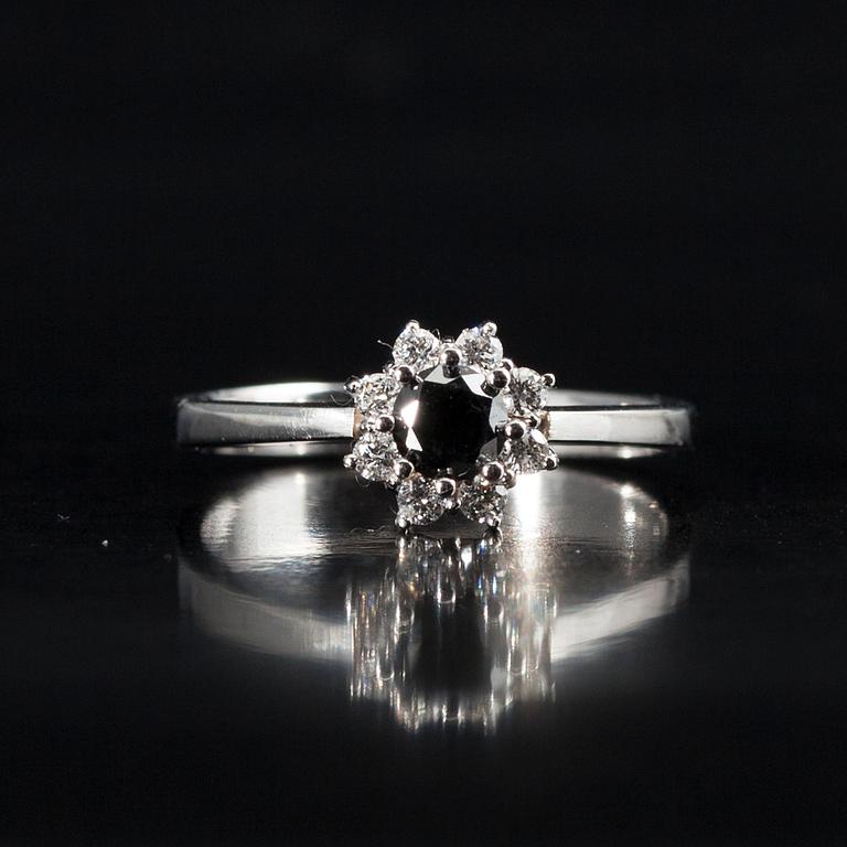 RING, vitguld 14K, briljantslipade diamanter. Mittstenen svartfärgad diamant 0,38 ct, 8 sidostenar tot. 0,18 ct. Intyg.