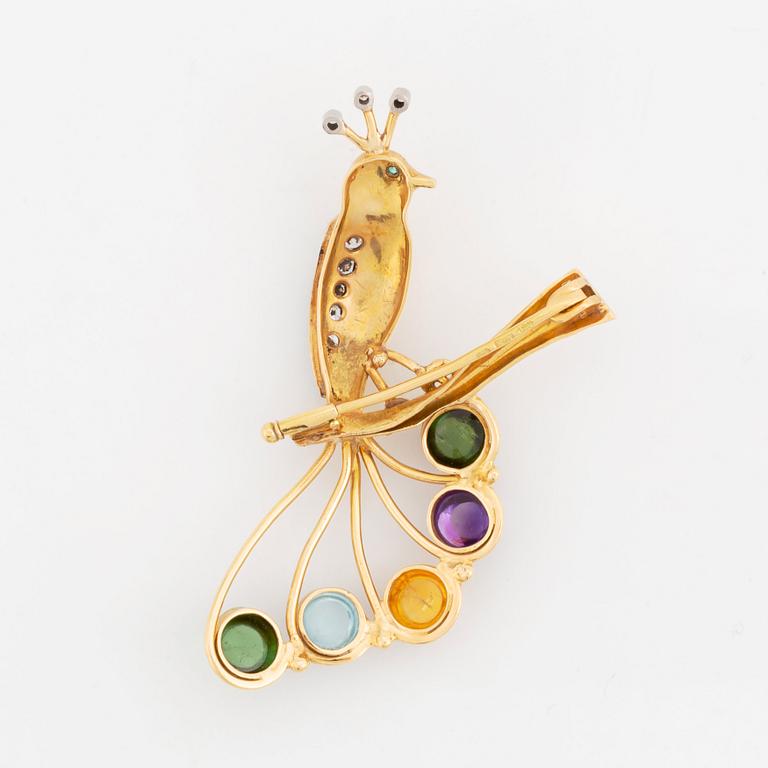 An 18K gold brooch in the form of a parrot with colored gemstones and round brilliant-cut diamonds.