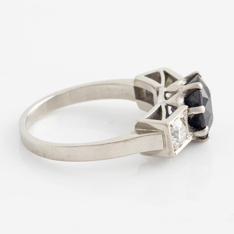 Ring, white gold, with dark sapphire and two brilliant-cut diamonds,