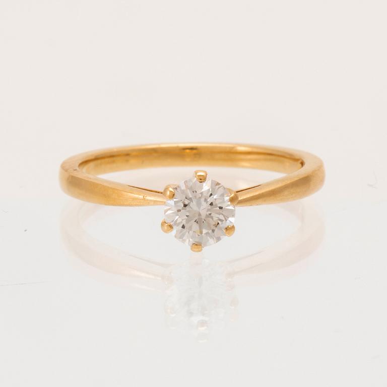 An 18K gold solitaire ring set with a round brilliant-cut diamond with GIA certificate.