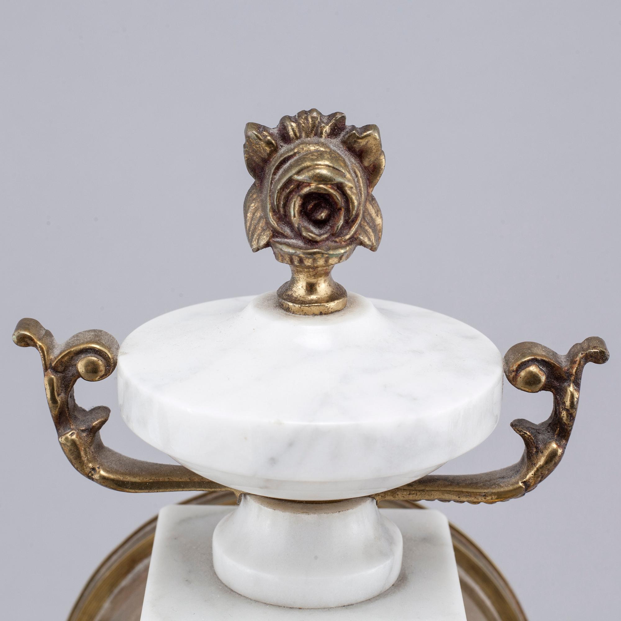 A French mantlepiece clock and a pair of candelabras, first half of the 20th century.