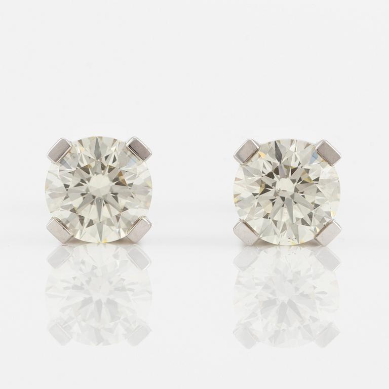 A pair of 18K gold earrings with round brilliant-cut diamonds.