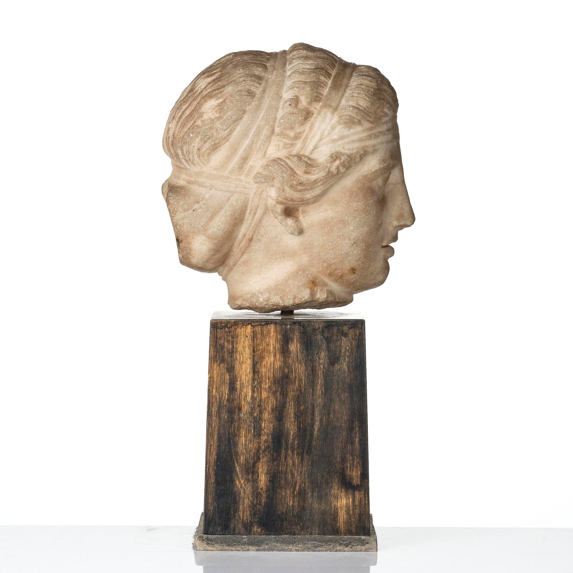A Greek marble head of a deity wearing a Dionysiac fillet, Hellenistic style presumably 16th century.