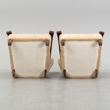 A pair of Danish lounge chairs with sheepskin upholstery.