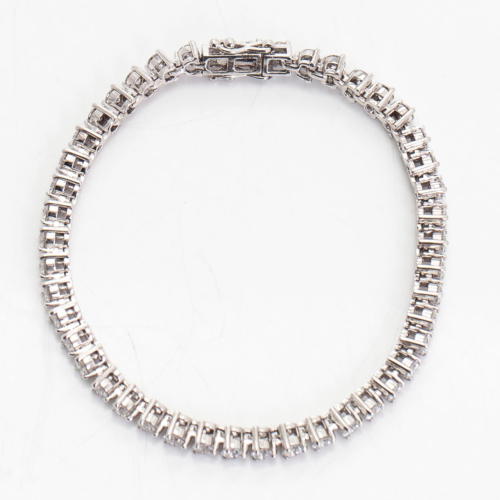 An 18K white gold tennis bracelet, with brilliant-cut diamonds.