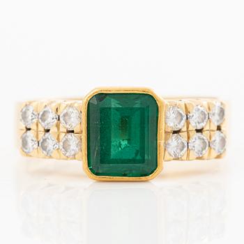 18K gold ring with a faceted emerald and round brilliant-cut diamonds.