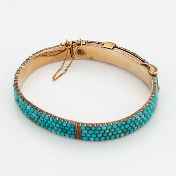 A silver and turquoise bracelet.