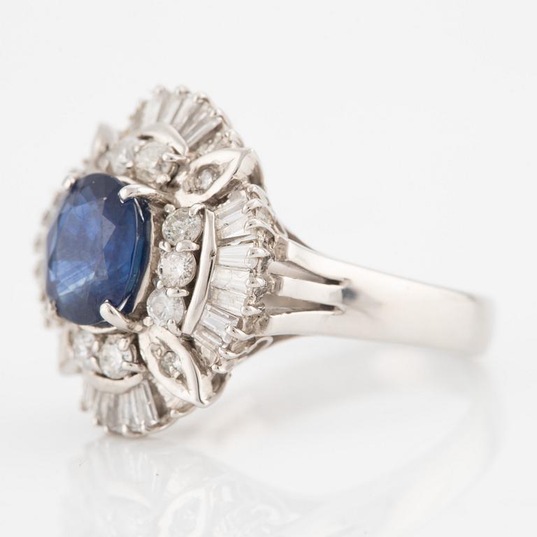 Ring in platinum set with a faceted sapphire and round brilliant- and baguette-cut diamonds.