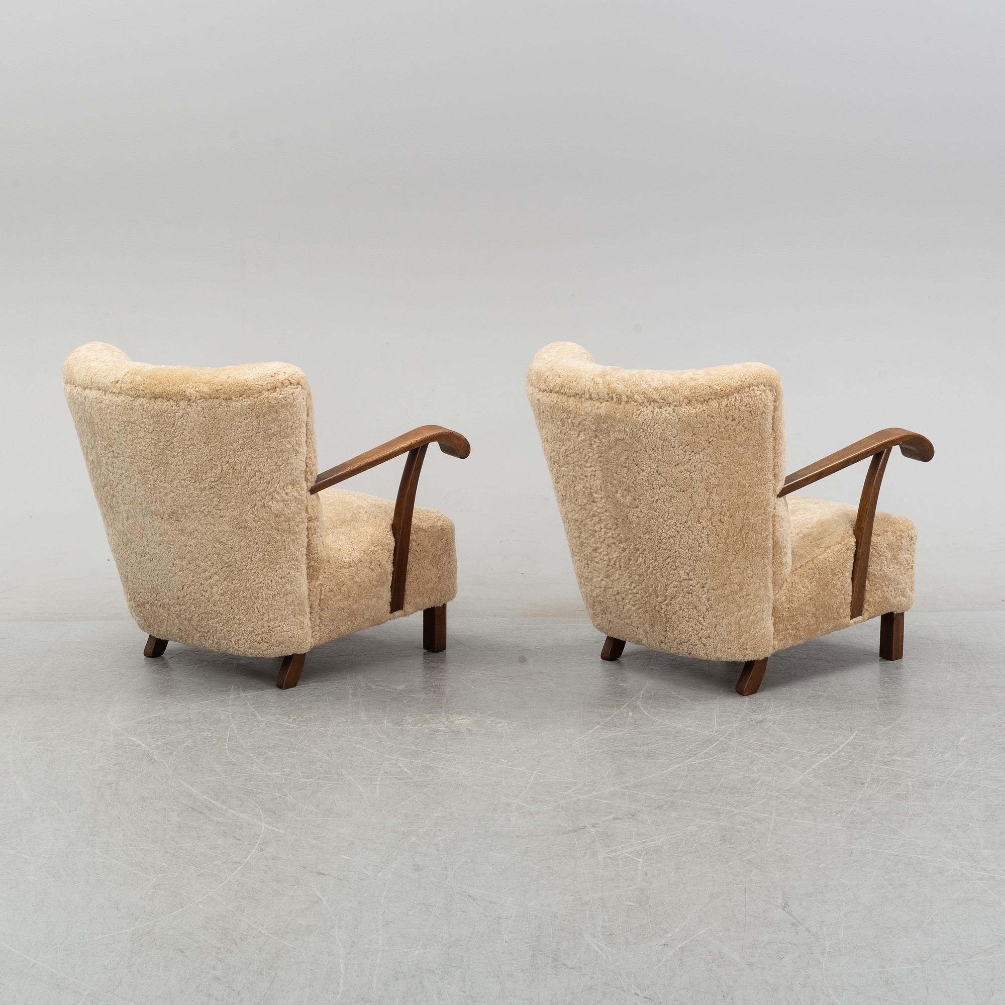 A pair of Danish lounge chairs with sheepskin upholstery.