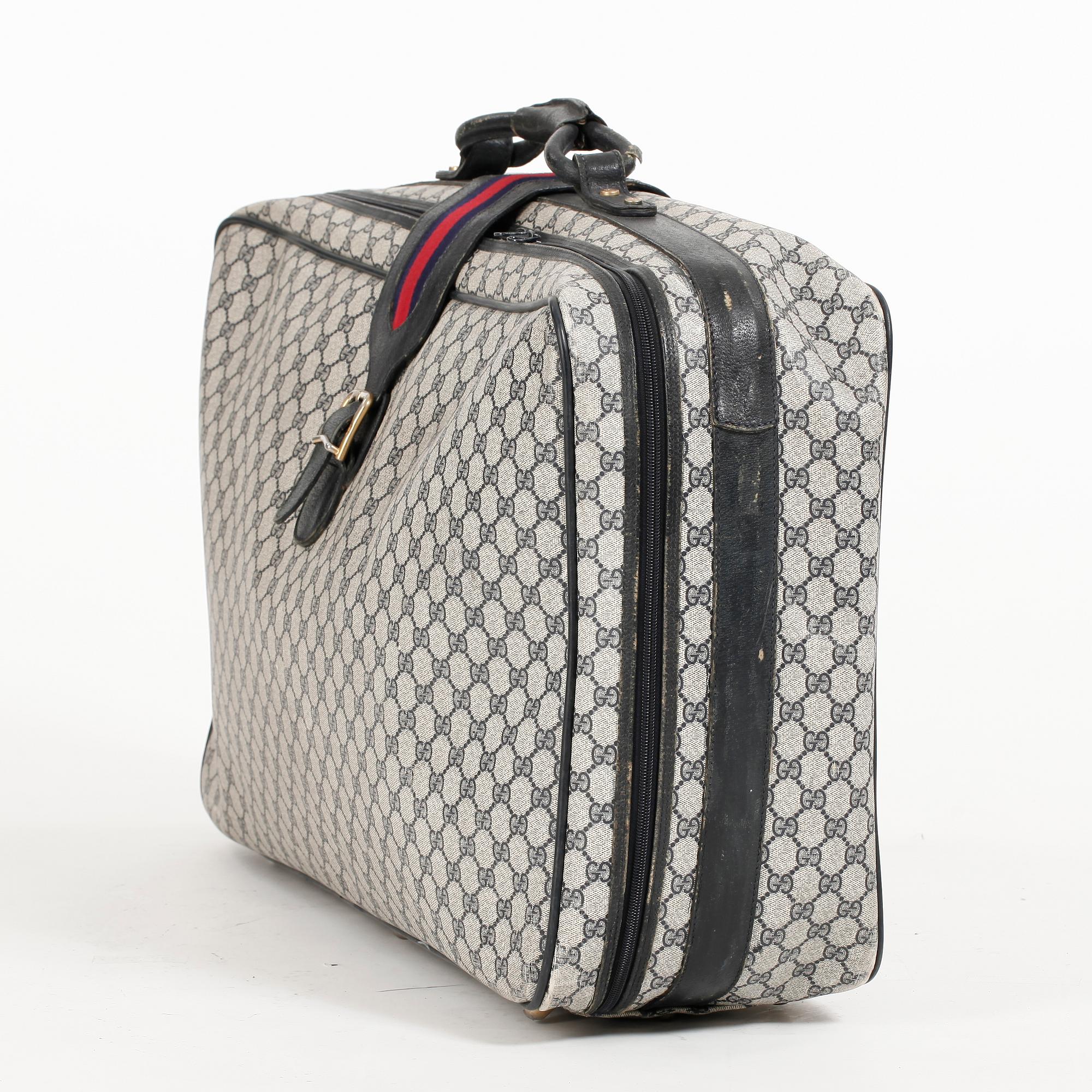 GUCCI, a blue monogram canvas suitcase.