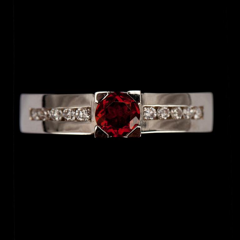 RING, vitguld 14K med granat 0,40 ct. och 10 st briljantslipade diamanter tot. 0,16 ct. Vikt 5 g.