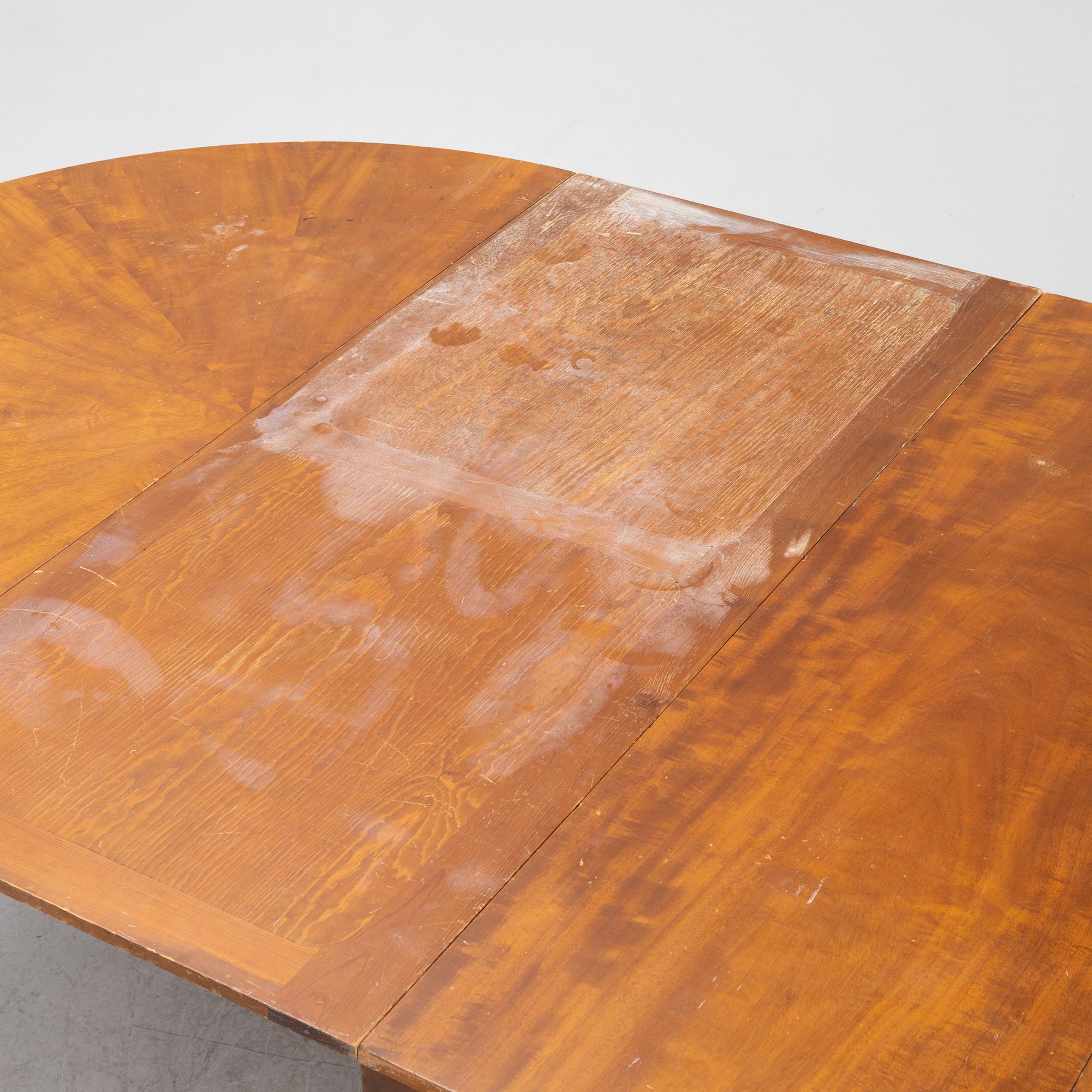 A mahogany-veneered dining table, first half of the 20th century.
