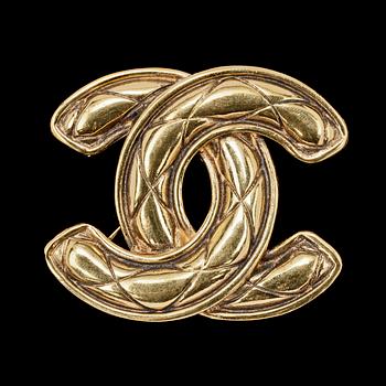 1233. A golden metal brooch by Chanel.